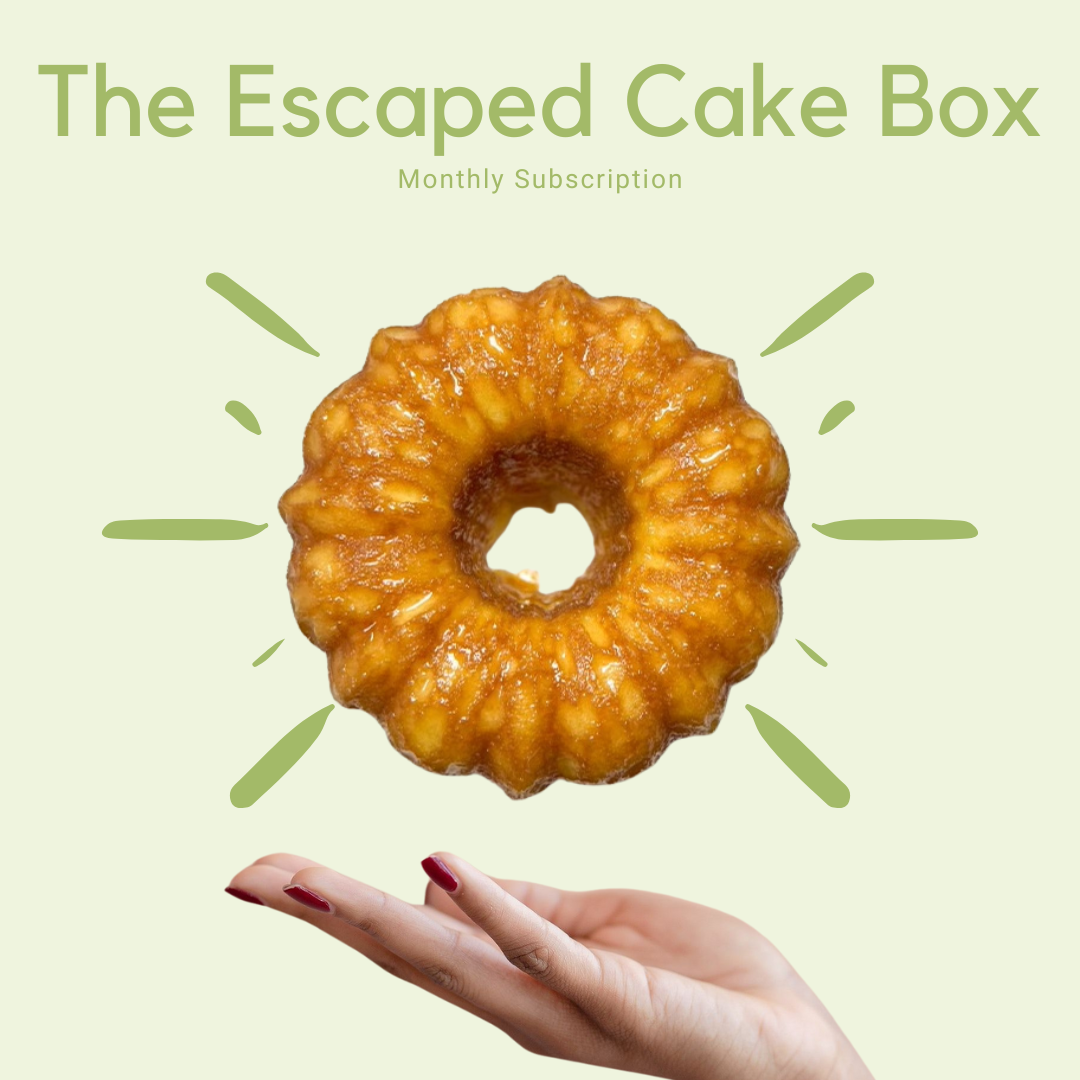 Vanilla rum cake floating above a hand with 'The Escaped Cake Box - monthly subscription' text on a light green background
