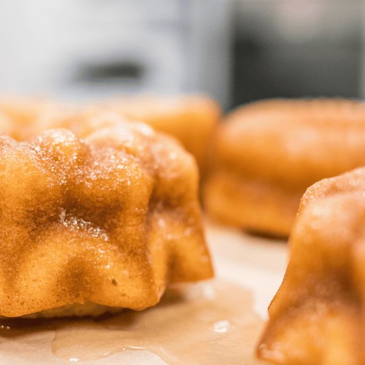 Close-up of a vanilla rum cake with a golden-brown crust, drizzled with glaze.